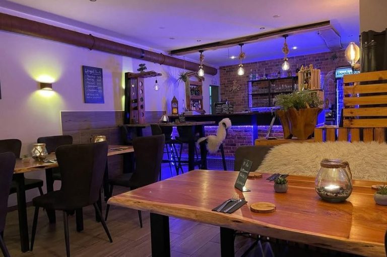 Gemütliches Restaurant mit Holztischen, modernem Licht und einer stilvollen Bar.