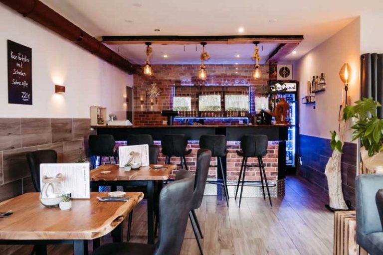 Modernes Restaurant mit Holzinterieur, Bar und stilvoller Beleuchtung. Tische für Gäste.